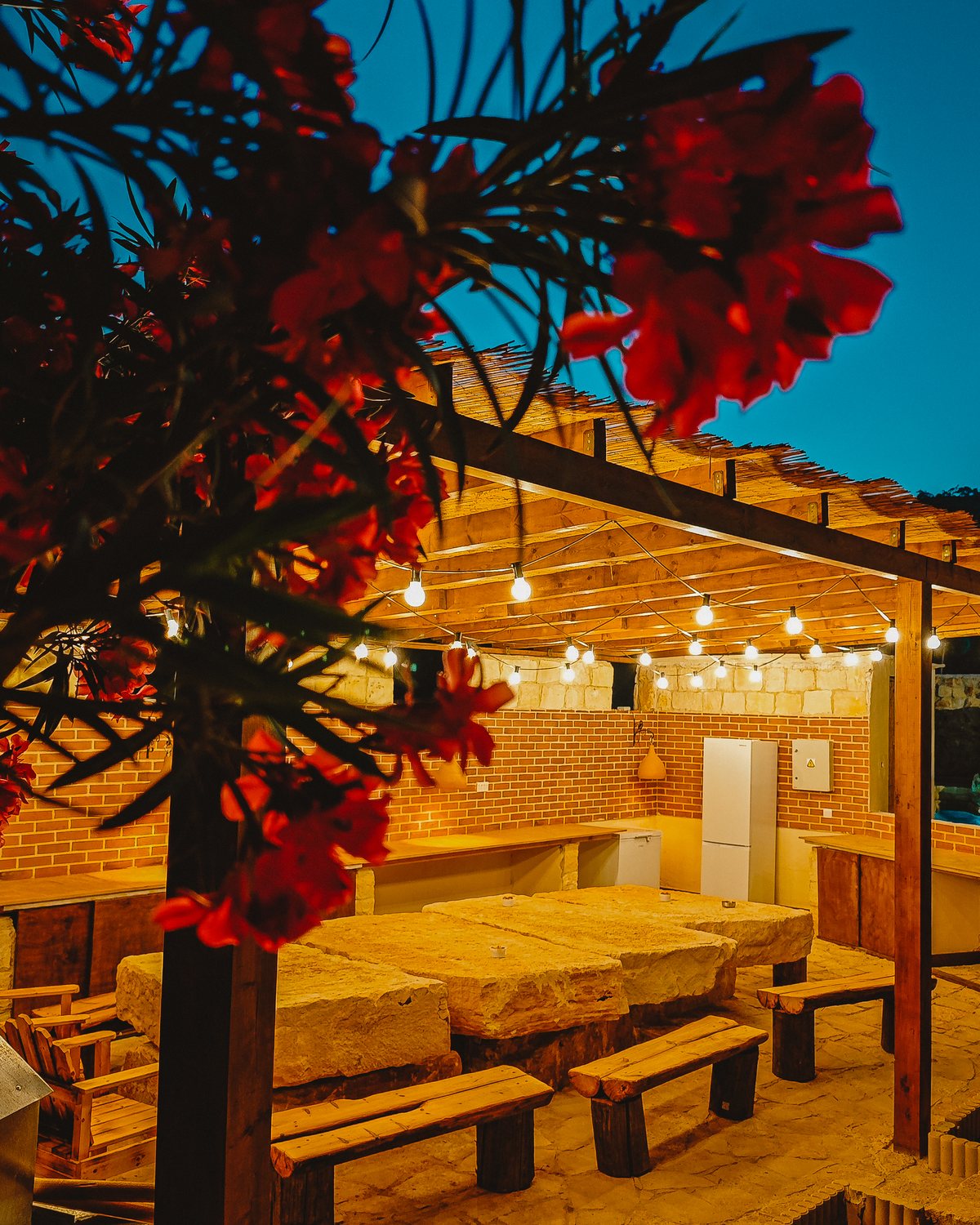 Wedding table set under hanging lights at Kleos courtyard