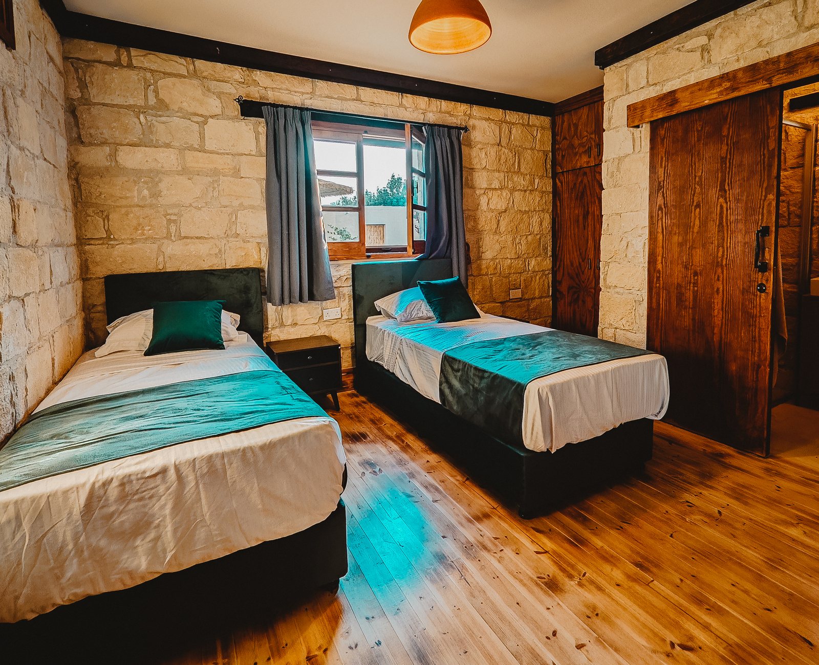 Bedroom suite at Estia Guest House with linen bed and stone walls