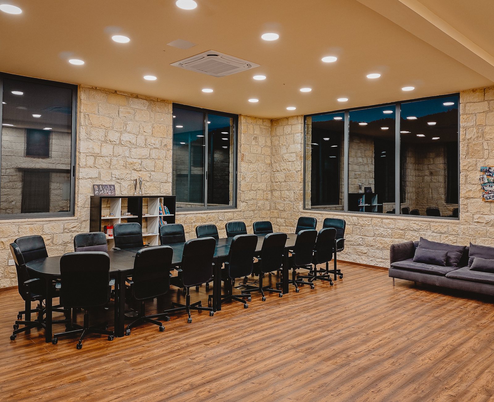 Interior of the Kleos seminar hall with arched windows and modular seating